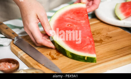 Wassermelone in Würfel schneiden für die Zubereitung von Schokolade Wassermelone beißt. Stockfoto