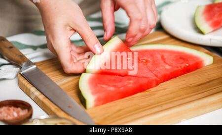 Wassermelone in Würfel schneiden für die Zubereitung von Schokolade Wassermelone beißt. Stockfoto