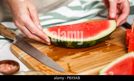 Wassermelone in Würfel schneiden für die Zubereitung von Schokolade Wassermelone beißt. Stockfoto