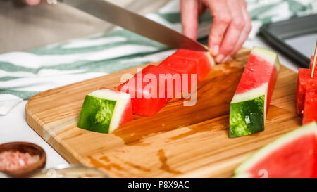 Wassermelone in Würfel schneiden für die Zubereitung von Schokolade Wassermelone beißt. Stockfoto