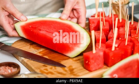 Wassermelone in Würfel schneiden für die Zubereitung von Schokolade Wassermelone beißt. Stockfoto
