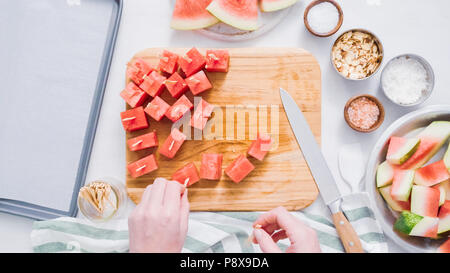 Wassermelone in Würfel schneiden für die Zubereitung von Schokolade Wassermelone beißt. Stockfoto