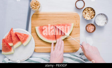 Wassermelone in Würfel schneiden für die Zubereitung von Schokolade Wassermelone beißt. Stockfoto