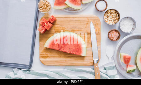 Wassermelone in Würfel schneiden für die Zubereitung von Schokolade Wassermelone beißt. Stockfoto