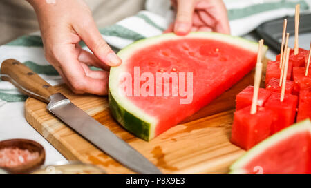 Wassermelone in Würfel schneiden für die Zubereitung von Schokolade Wassermelone beißt. Stockfoto