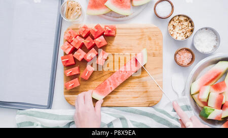 Wassermelone in Würfel schneiden für die Zubereitung von Schokolade Wassermelone beißt. Stockfoto