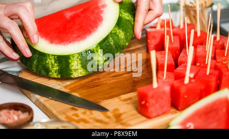 Wassermelone in Würfel schneiden für die Zubereitung von Schokolade Wassermelone beißt. Stockfoto