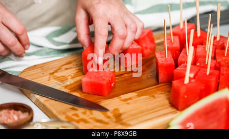Wassermelone in Würfel schneiden für die Zubereitung von Schokolade Wassermelone beißt. Stockfoto