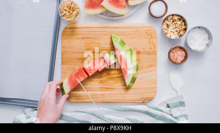 Wassermelone in Würfel schneiden für die Zubereitung von Schokolade Wassermelone beißt. Stockfoto