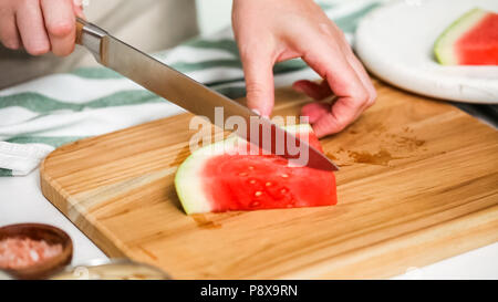 Wassermelone in Würfel schneiden für die Zubereitung von Schokolade Wassermelone beißt. Stockfoto