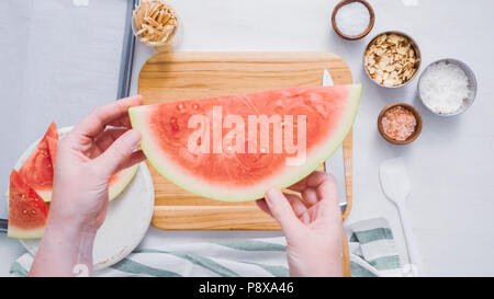 Wassermelone in Würfel schneiden für die Zubereitung von Schokolade Wassermelone beißt. Stockfoto