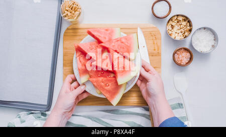 Wassermelone in Würfel schneiden für die Zubereitung von Schokolade Wassermelone beißt. Stockfoto