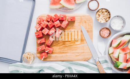 Wassermelone in Würfel schneiden für die Zubereitung von Schokolade Wassermelone beißt. Stockfoto