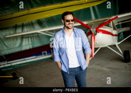 Hübscher junger Mann im Hangar Stockfoto