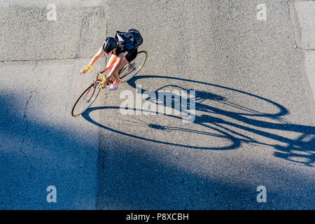 Radfahrer und lange Schatten, Vancouver, British Columbia, Kanada. Stockfoto