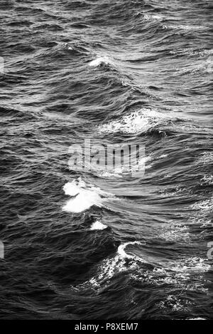 Ocean Waves mit kleinen weißen Kappen Hintergrund in Schwarz und Weiß Stockfoto