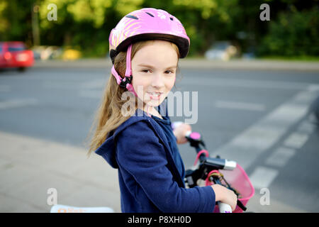 Süße kleine Vorschüler Mädchen mit dem Fahrrad in einer Stadt tragen Helm auf Sommer Tag Stockfoto