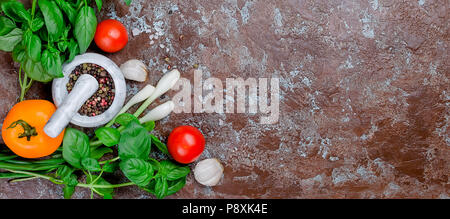Reife rote und gelbe Tomaten, grüne Zwiebeln und Basilikum, Knoblauch, Salz und Gewürze auf einem dunklen Stein Hintergrund. Ansicht von oben, Kopieren. Stockfoto
