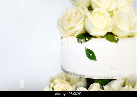 Köstliche weiße Hochzeitstorte mit echten Blumen dekoriert Stockfoto