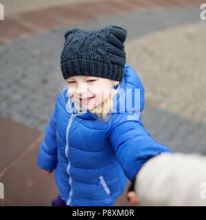 Süße kleine Mädchen ihre Mütter Hand draußen halten Frühling Stockfoto