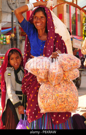 Patan: Indische Frau mit ihrer Tochter und Kräutertee Beutel in der Hand. Stockfoto