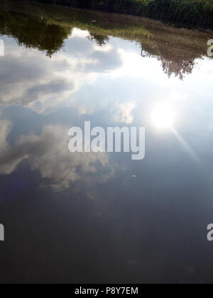 Nach oben sky Reflexion der Himmel und Wolken im Wasser von der Seite eines Bootes an einem heißen sonnigen Tag in Doncaster, South Yorkshire gesehen Stockfoto