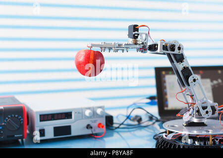 Roboterarm mit Apfel. Stockfoto