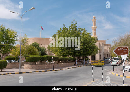 Altstadt von Nizwa in westlichen Oman mit Mauern der Burg/Qasr sichtbar zusammen mit Menschen und Autos Stockfoto