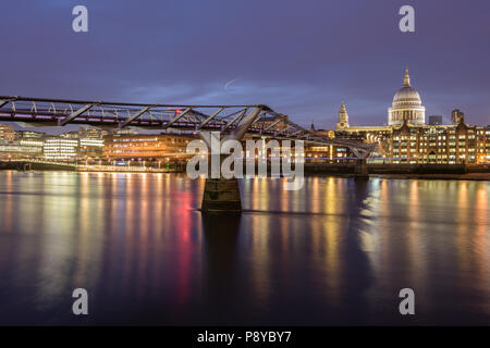 Lange Belichtung Landschaft Blick auf die St. Pauls Kathedrale und der Londoner Millennium Fußgängerbrücke in der Nacht mit Beleuchtung in der Themse wider Stockfoto