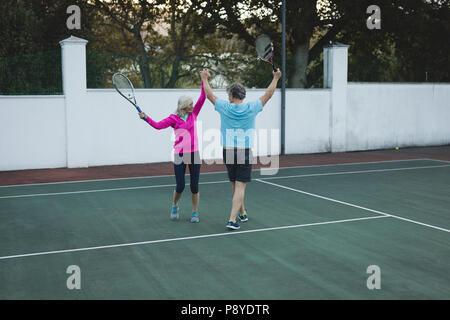 Senior paar Jubel in Tennisplatz Stockfoto