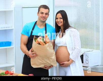Mann und die schwangere Frau mit einem Paket von baguettes Stockfoto