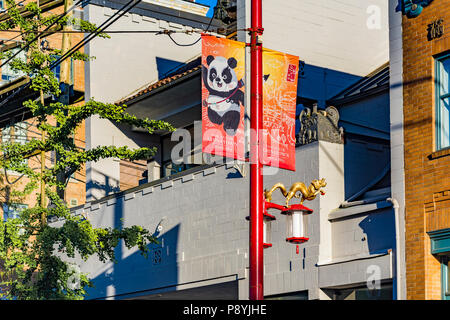 Reich verzierte Lamp Post mit vergoldeten Drachen und Panda Banner, Chinatown, Vancouver, British Columbia, Kanada. Stockfoto