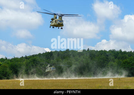 Us Army CH-47 Chinook Helicopter flight Crews mit Firma B, 2. Allgemeine Unterstützung Aviation Battalion, 4th Aviation Regiment, 4 Combat Aviation Brigade, 4 Infanterie Division, nehmen Sie nach Erhalt der Kraftstoff aus Erdöl liefern Spezialisten mit 404Th Aviation Support Bataillons, auf einen Sprung vorwärts Bereich tanken Punkt (KASSENAERZTE) während eines Readiness Training übung in Hohenfels, Deutschland, 12. Juli 2018. Soldaten des 4. CAB sind derzeit in Europa zur Unterstützung der Atlantischen lösen, eine in den USA bemühen sich NATO-Verpflichtungen durch US-drehen-basierte Einheiten in der gesamten Europäischen t erfüllen bereitgestellt Stockfoto