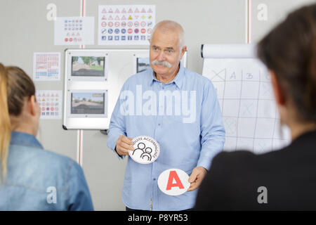 Stattliche senior Fahrlehrer in einer Klasse Stockfoto