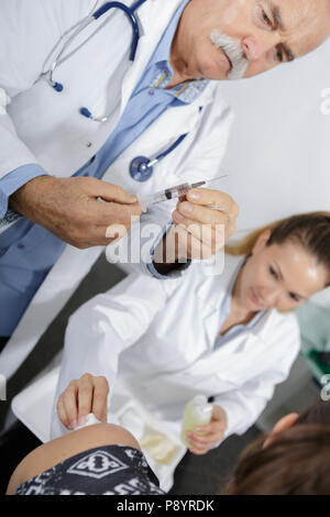 Arzt Schutzhandschuhe Holding eine Spritze Stockfoto