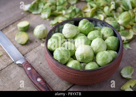 Raw Rosenkohl in Keramik Schüssel auf natürliche Holz Schreibtisch Schreibtisch. Stockfoto