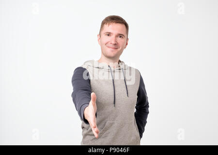 Hübscher junger Mann streckte die Hand zu schütteln. Stockfoto