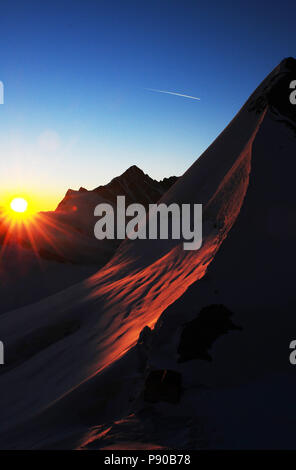 Panoramablick bei Sonnenaufgang von Europas höchsten Berghütte der Mönchshütte über die Berner Alpen Stockfoto