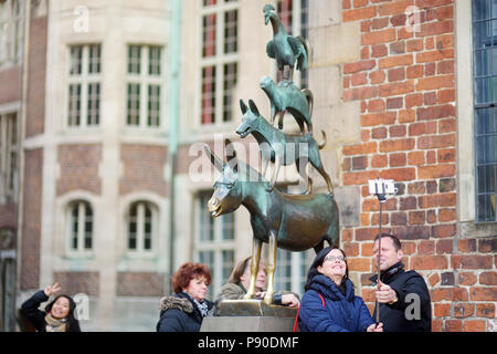 BREMEN, Deutschland - 23 März 2016: Touristen, die Bilder von sich selbst durch die berühmte Statue im Zentrum von Bremen, der Darstellung der Esel, Hund, Katze und Stockfoto