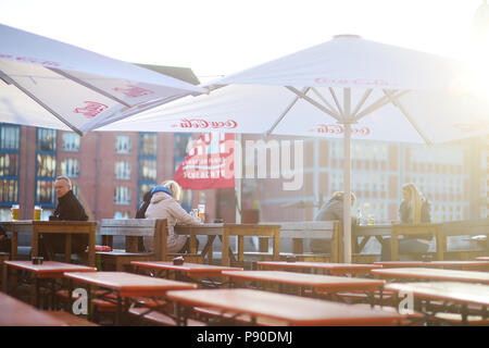 BREMEN, Deutschland - 23 März 2016: Touristen mit einem Bier in einem Restaurant auf einem embarktment der Weser in Bremen. Stockfoto