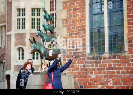 BREMEN, Deutschland - 23 März 2016: Touristen, die Bilder von sich selbst durch die berühmte Statue im Zentrum von Bremen, der Darstellung der Esel, Hund, Katze und Stockfoto