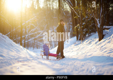 Junge Vater und Tochter Spaß mit einem Taschenspielertrick im schönen Winter Park auf Sonnenuntergang Stockfoto