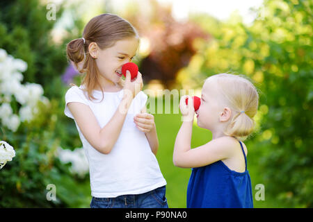 Glückliche kleine Schwestern tragen rote Nasen clown Spaß zusammen auf sonnigen Sommertag im Freien Stockfoto