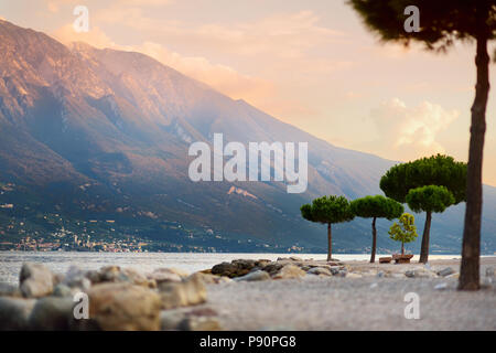Einen malerischen Sonnenuntergang am Strand von Limone sul Garda, einer kleinen Stadt, Gemeinde in der Provinz Brescia in der Lombardei, am westlichen Ufer des Sees G gelegen Stockfoto