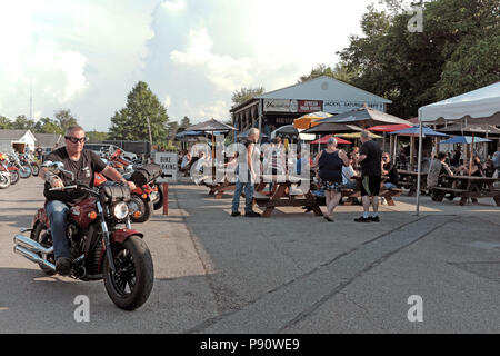 Ein Motorradfahrer fährt aus dem Fahrrad Parkplatz, eine Bar, populär bei Biker in Geneva-on-the-Lake, Ohio, USA. Stockfoto