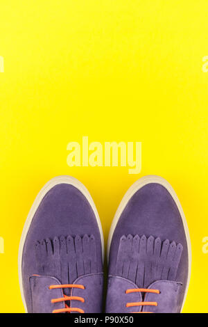 Flach von Wildleder Schuhe auf Bold gelbes Papier Hintergrund mit kopieren. Ansicht von oben von Frau casual Outfit. Trendy hipster look Top View Stockfoto