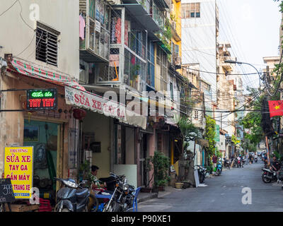 Eine Gasse gesäumt von Geschäften und hoher Dichte Wohnungen in Ho Chi Minh City, Vietnam. Stockfoto