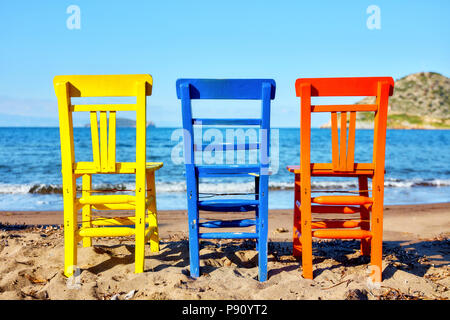 Zurück nach antiken Holzmöbeln gelb blau und orange Liegen am Strand an einem sonnigen Tag Stockfoto