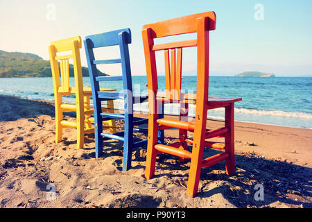 Zurück nach antiken Holzmöbeln gelb blau und orange Liegen am Strand an einem sonnigen Tag Stockfoto