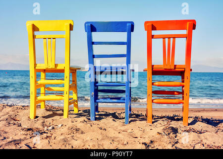 Zurück nach antiken Holzmöbeln gelb blau und orange Liegen am Strand an einem sonnigen Tag Stockfoto